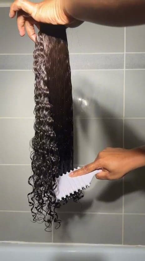 Curly lock being detangled with a comb